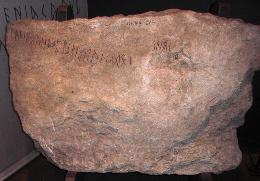 Image of the Kylver stone showing a string of runes followed by a stacked bindrune.