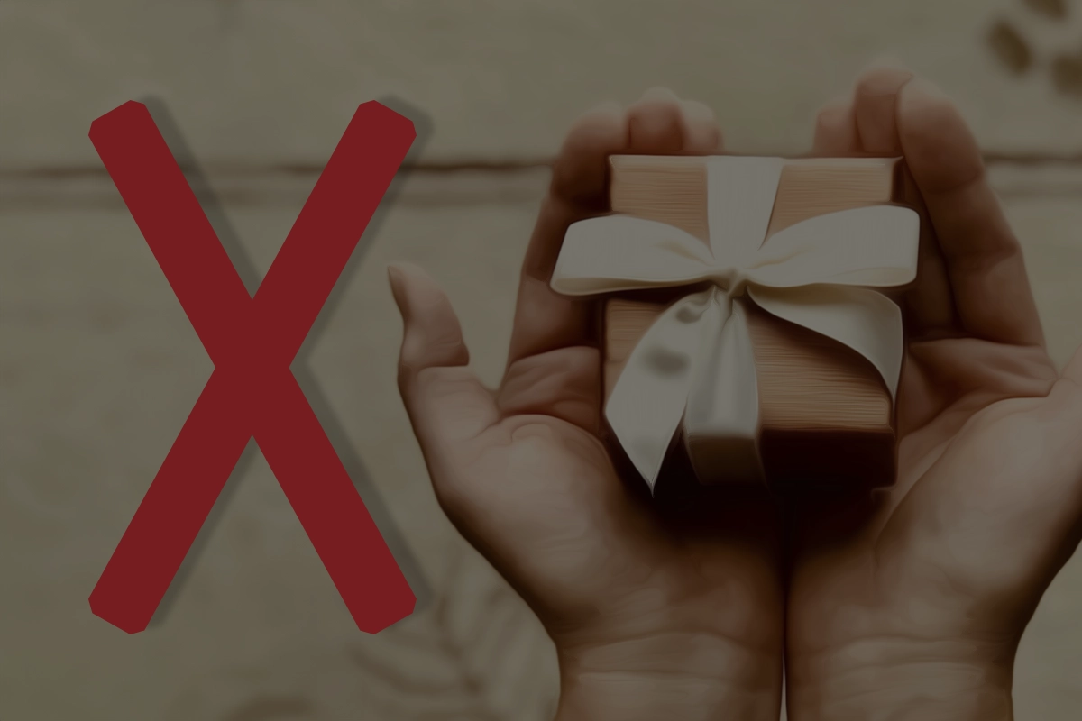 The image shows the Gebo rune in red on the left and on the right, two hands holding out a gift-wrapped package with a bow.